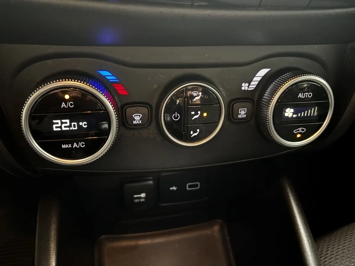 Gros plan sur les commandes de climatisation digitale du tableau de bord noir du Fiat Tipo blanc de 2021.