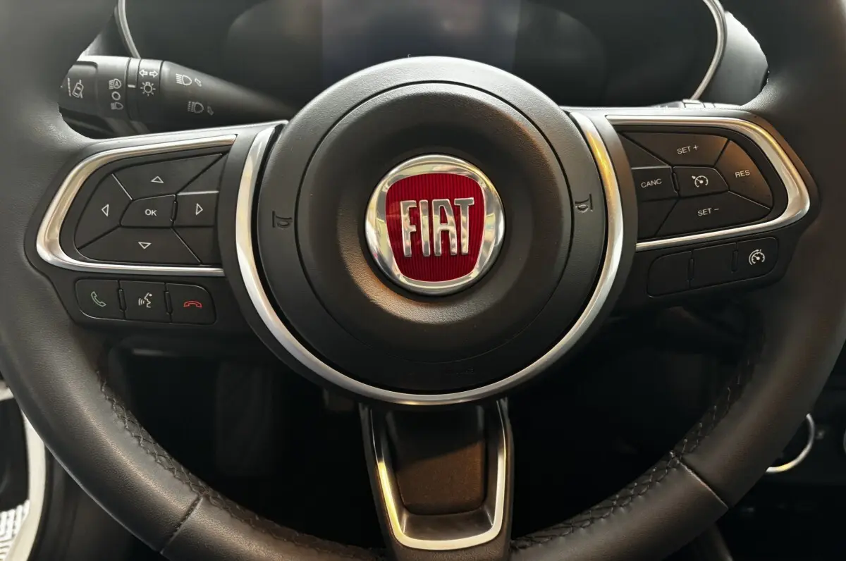 Gros plan sur le volant cuir et alu du Fiat Tipo 1.6 MultiJet 2021 avec commandes multifonctions intégrées.