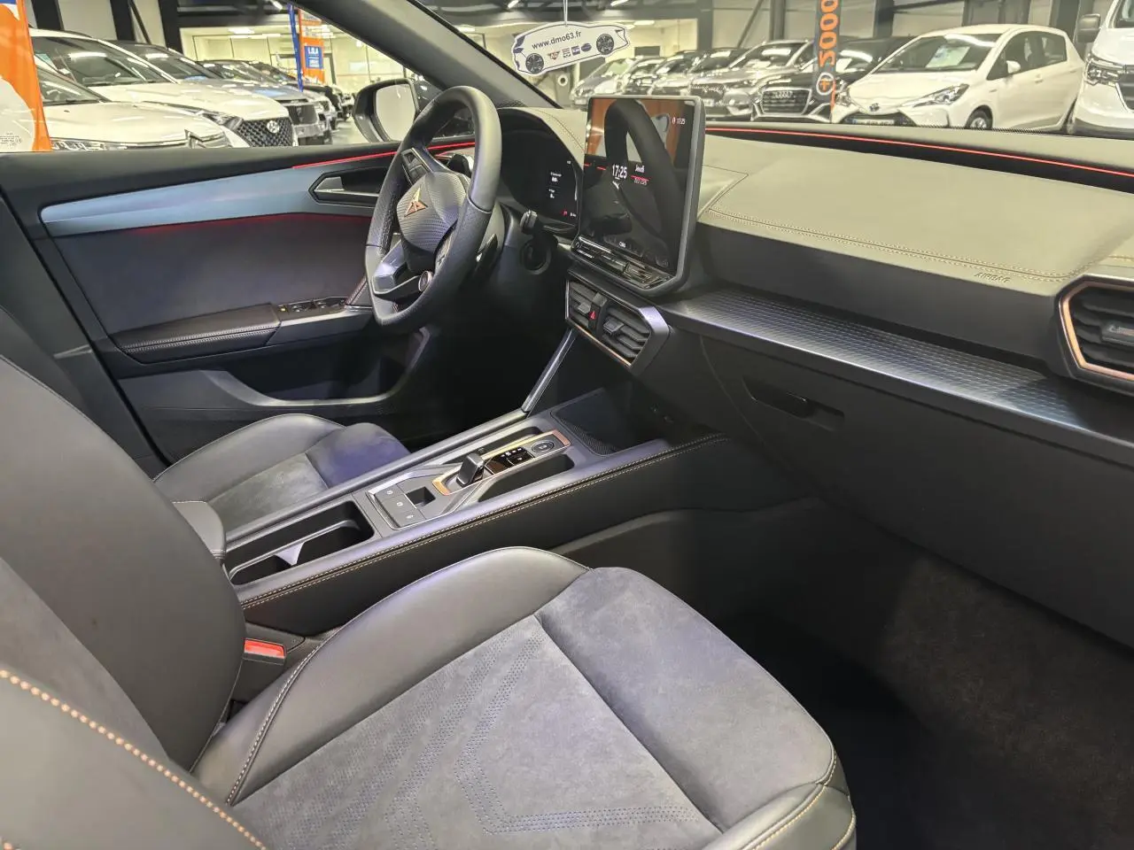 Vue intérieure côté conducteur de la CUPRA Leon 2026 noir midnight, avec tableau de bord texturé et surpiqûres cuivrées.