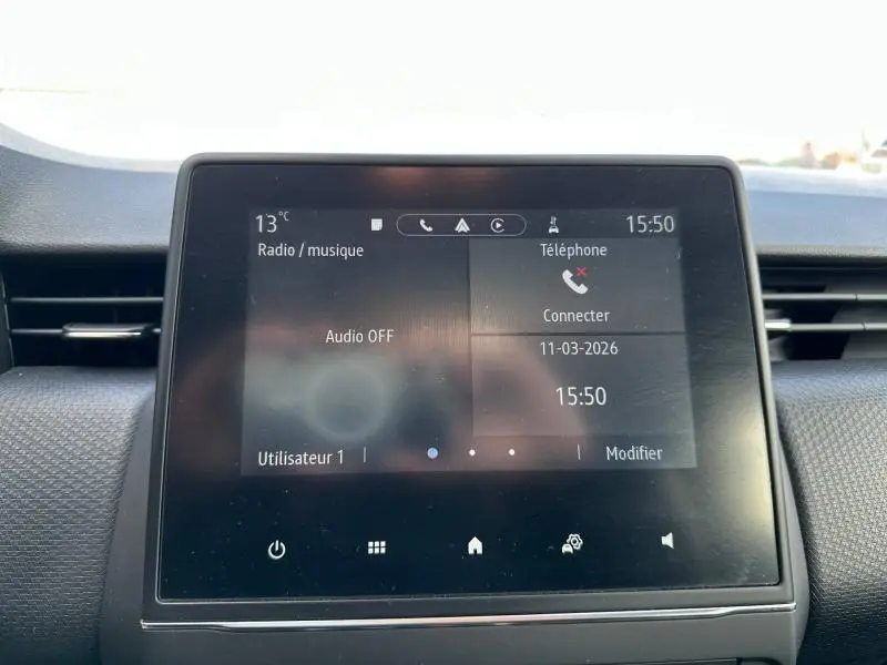 Écran tactile central de la Renault Clio 2023 gris, affichant les options radio et téléphone, vue de face.