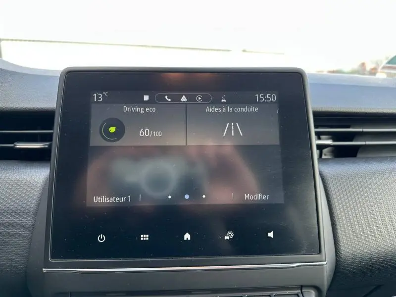 Écran tactile central du tableau de bord de la Renault Clio 2023, affichant les aides à la conduite et l'eco-driving.