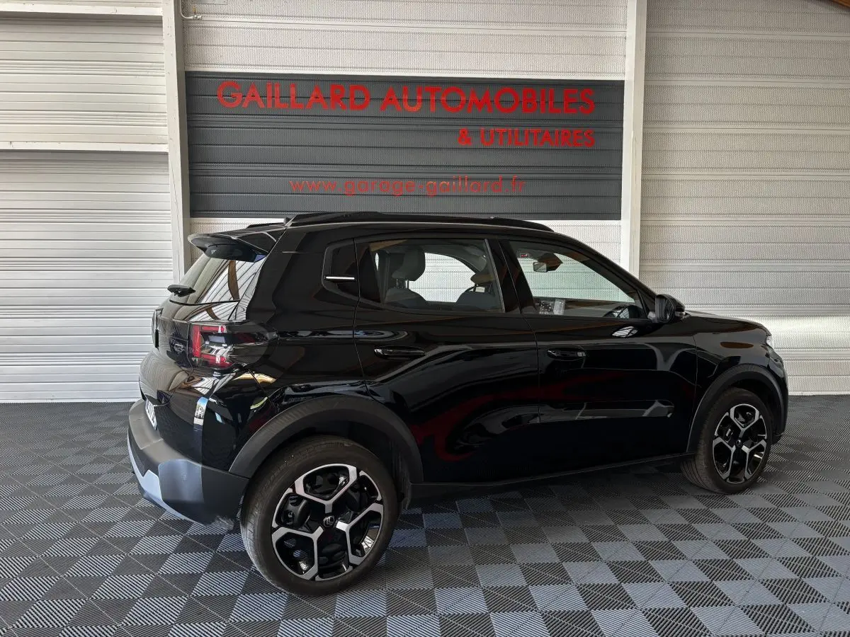 Vue latérale droite d'une Citroën C3 Turbo 100 BVM6 MAX noire, avec jantes distinctives et spoiler arrière visible.