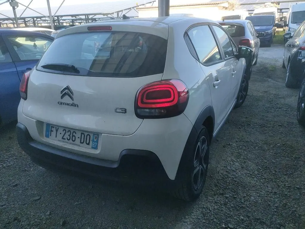 Vue 3/4 arrière droite d'une Citroën C3 Société blanche de 2021 avec feux arrière LED et jantes noires.