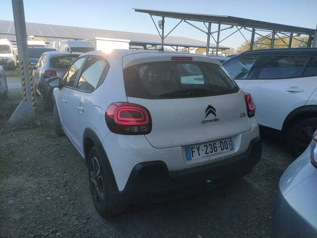 Vue 3/4 arrière d'une Citroën C3 Société blanche 2021 avec feux arrière LED et plaques françaises, stationnée en extérieur.