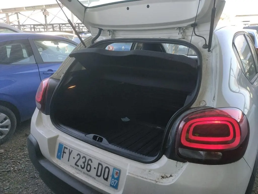 Vue arrière ouverte d'une Citroën C3 Société blanche de 2021, coffre vide avec feux arrière allumés.