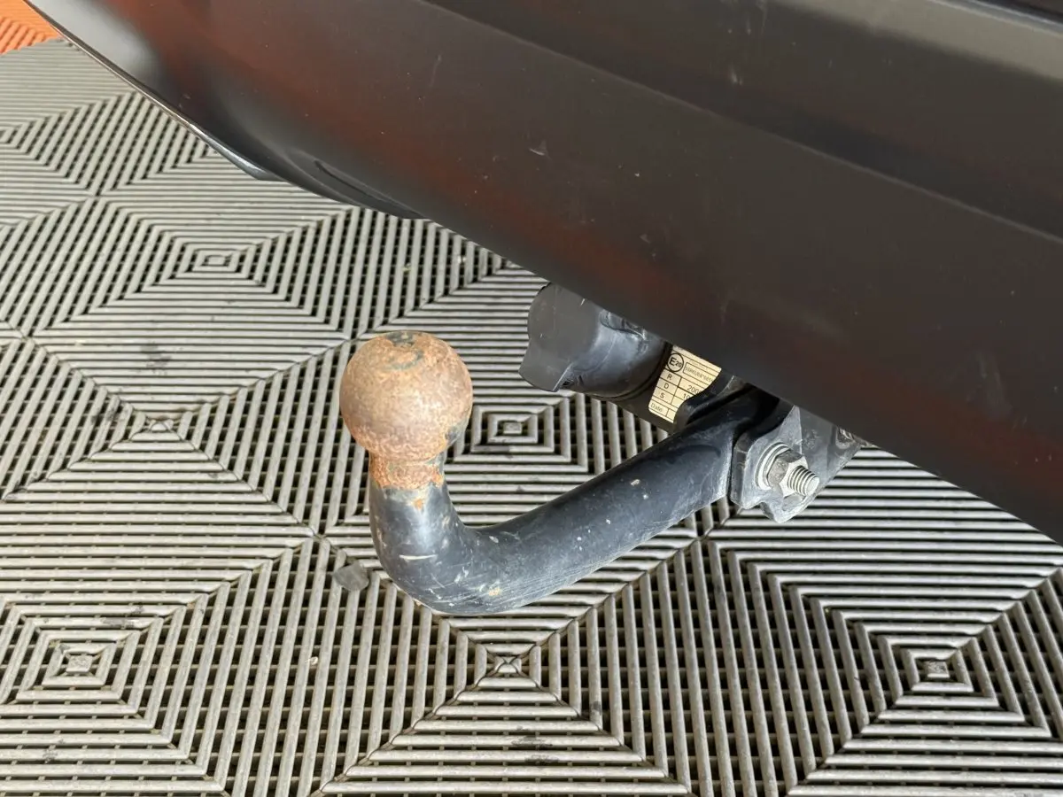 Gros plan sur l'attelage de remorque rouillé sous le pare-chocs arrière gris clair du Citroën C5 Aircross 2023.