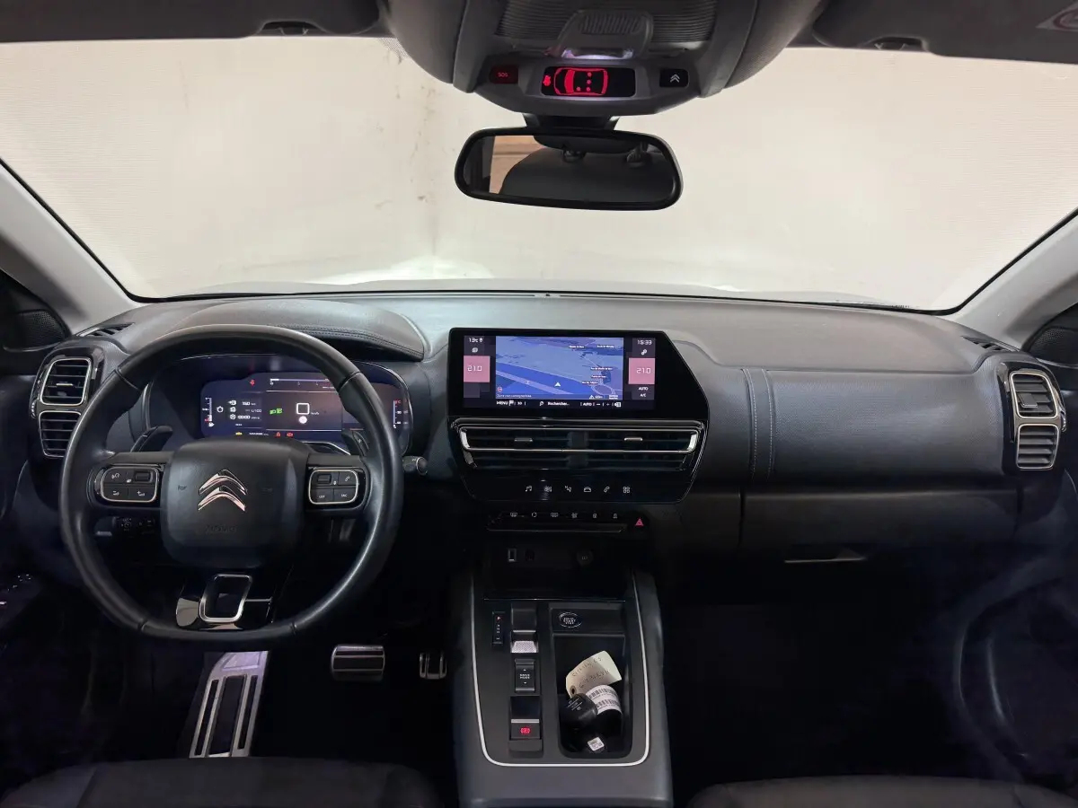 Vue intérieure frontale du tableau de bord noir du Citroën C5 Aircross 2023 avec écran tactile central et volant multifonctions.