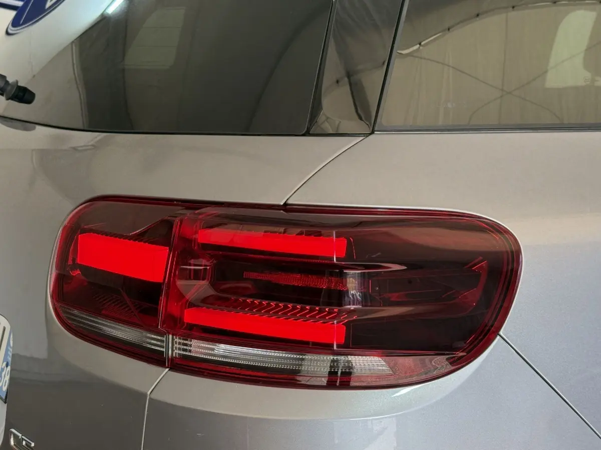 Gros plan sur le feu arrière droit rouge d’un Citroën C5 Aircross gris clair 2023, finition Shine.