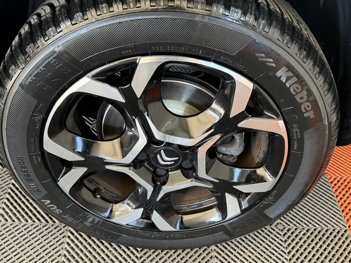 Gros plan sur la jante alliage bicolore noire et argent d’un Citroën C5 Aircross gris clair, vue latérale.