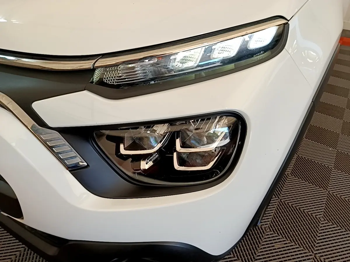 Gros plan sur le phare avant droit blanc d'une Citroën C3 2021 avec feux LED et détails chromés.