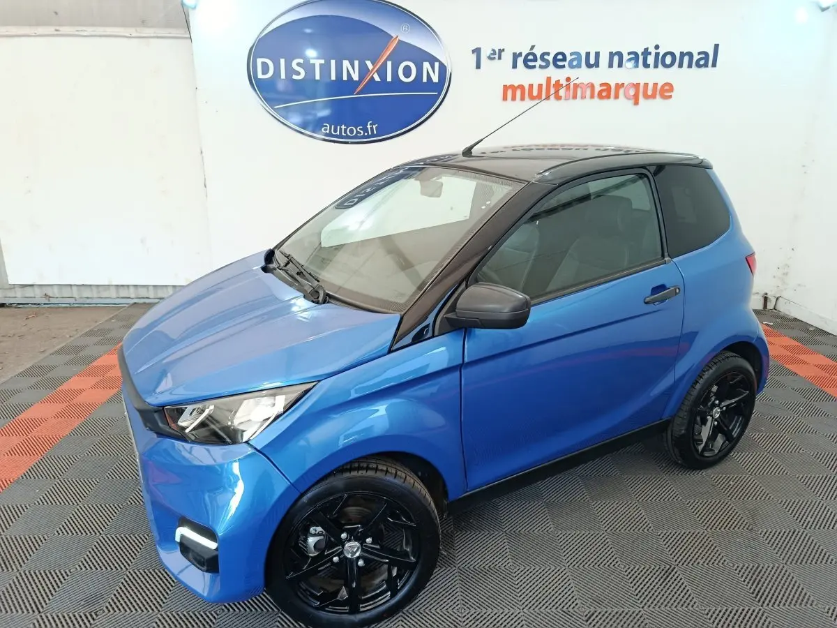 Vue 3/4 avant droit d'une Aixam Ambition 0.5 City Sport bleu 2024 avec toit noir et jantes noires.