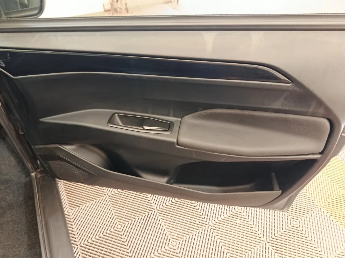Vue intérieure du panneau de porte côté conducteur de l'AIXAM AMBITION 0.5 CITY SPORT 2024 en bleu, avec poignée intégrée.