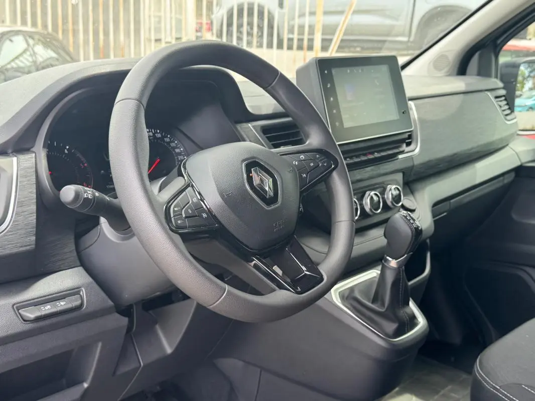 Vue intérieure côté conducteur du Renault Trafic Fourgon 2024, montrant le volant, tableau de bord et écran tactile central.