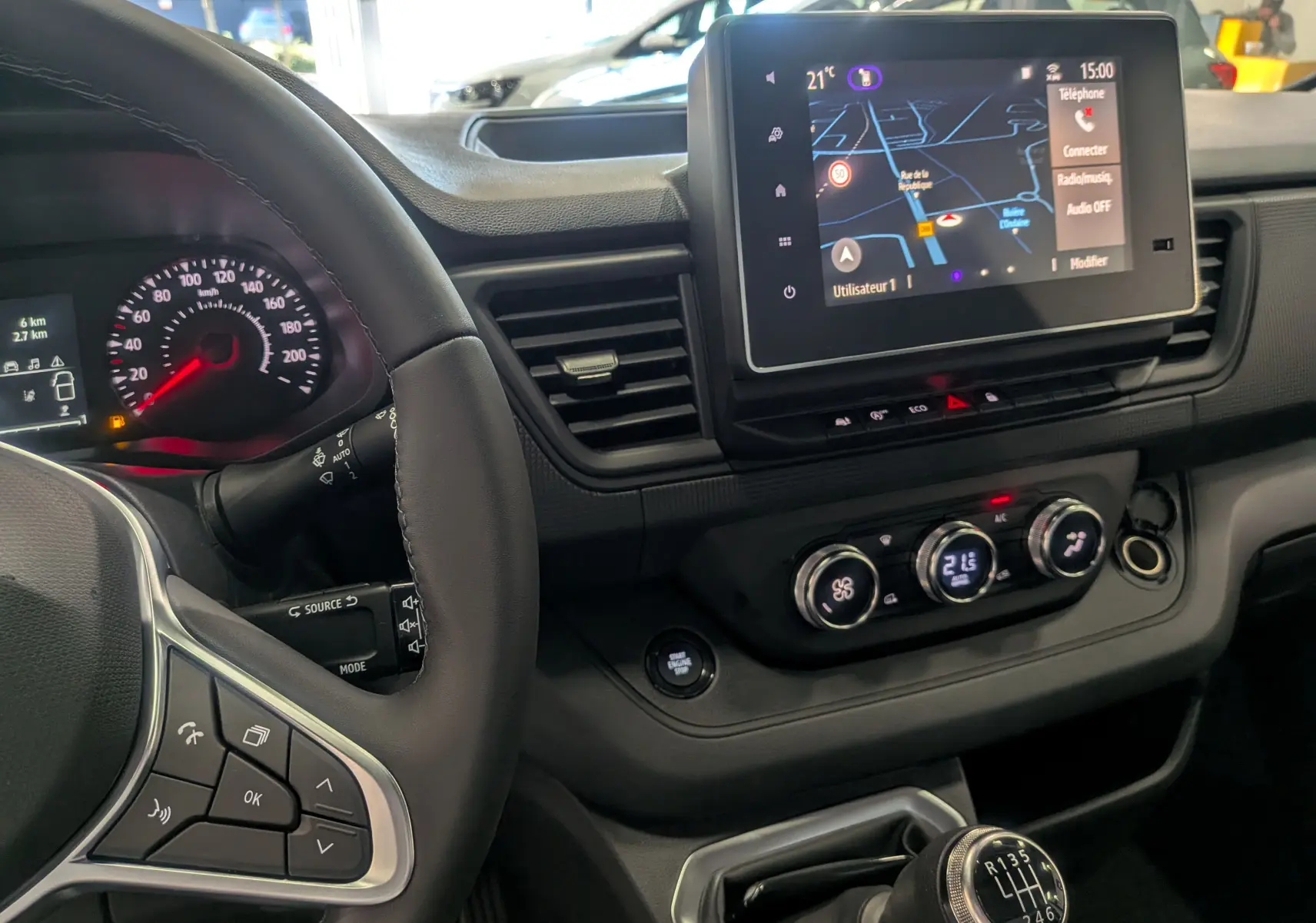 Vue intérieure du tableau de bord du Renault Trafic Fourgon L1H1 2025, avec écran tactile et volant multifonction noir.