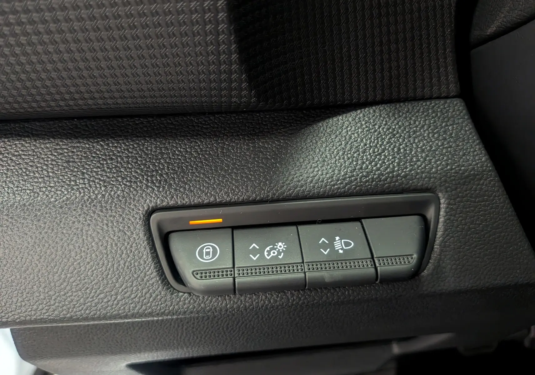 Gros plan sur les commandes de réglage d'éclairage et verrouillage intérieur du Renault Trafic Fourgon blanc glacier 2025.