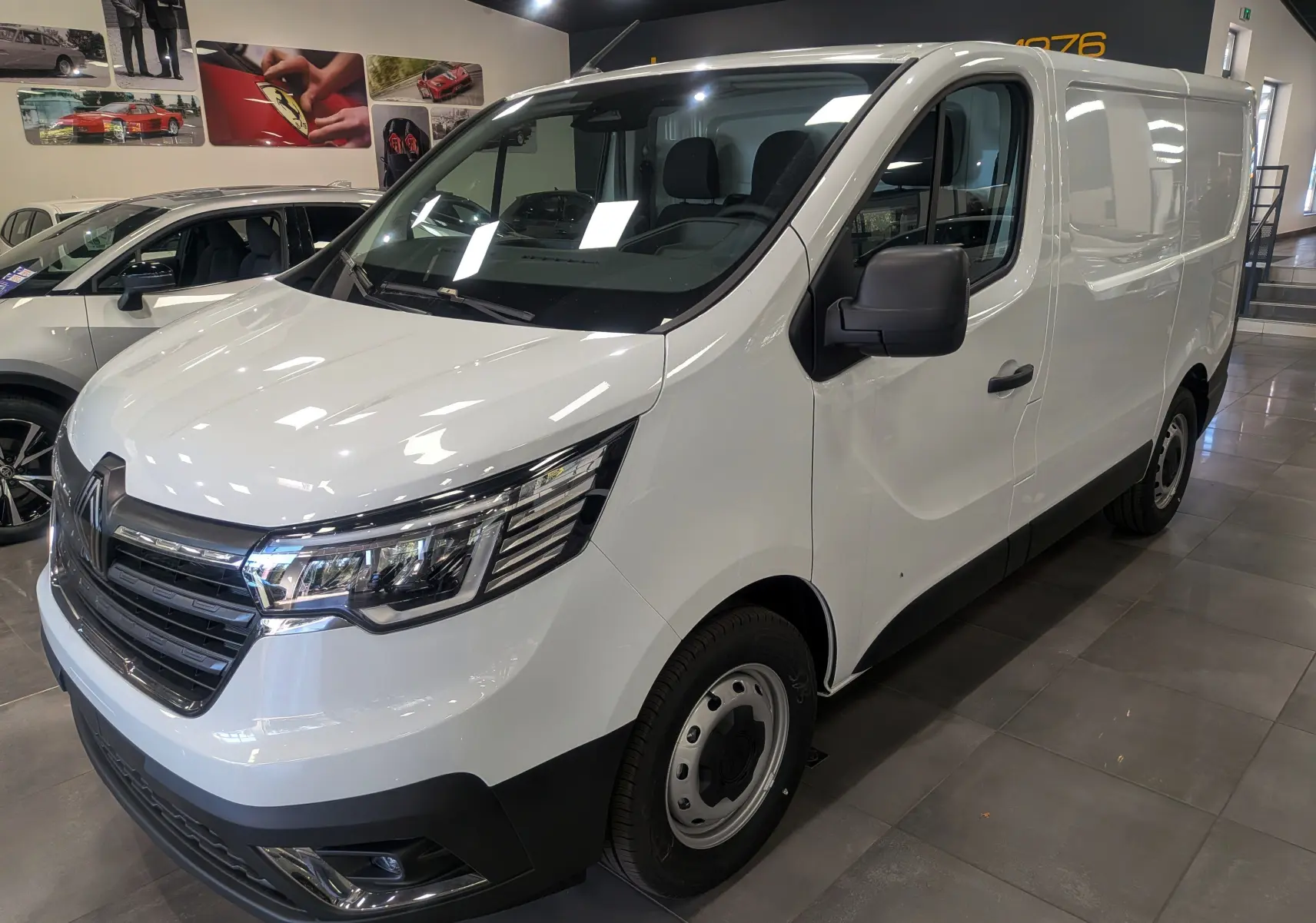 Renault Trafic Fourgon blanc glacier en 3/4 avant droit, avec calandre moderne et phares LED distinctifs.