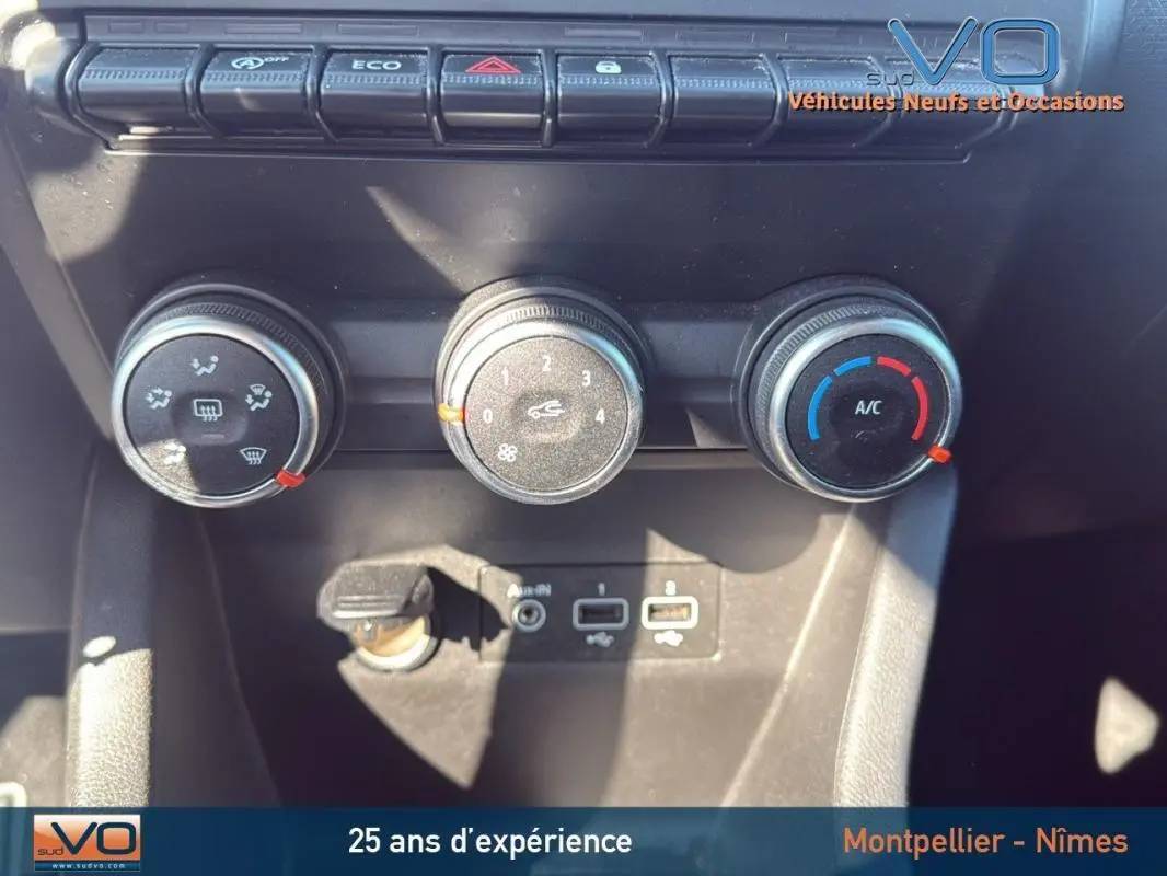 Vue rapprochée des commandes de climatisation manuelle et des ports USB dans une Renault Clio gris 2022 V TCe 90 Equilibre.