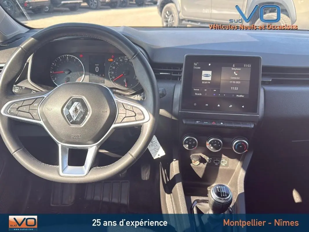 Vue intérieure du tableau de bord et volant de la Renault Clio gris 2022 avec boîte manuelle et écran tactile central.