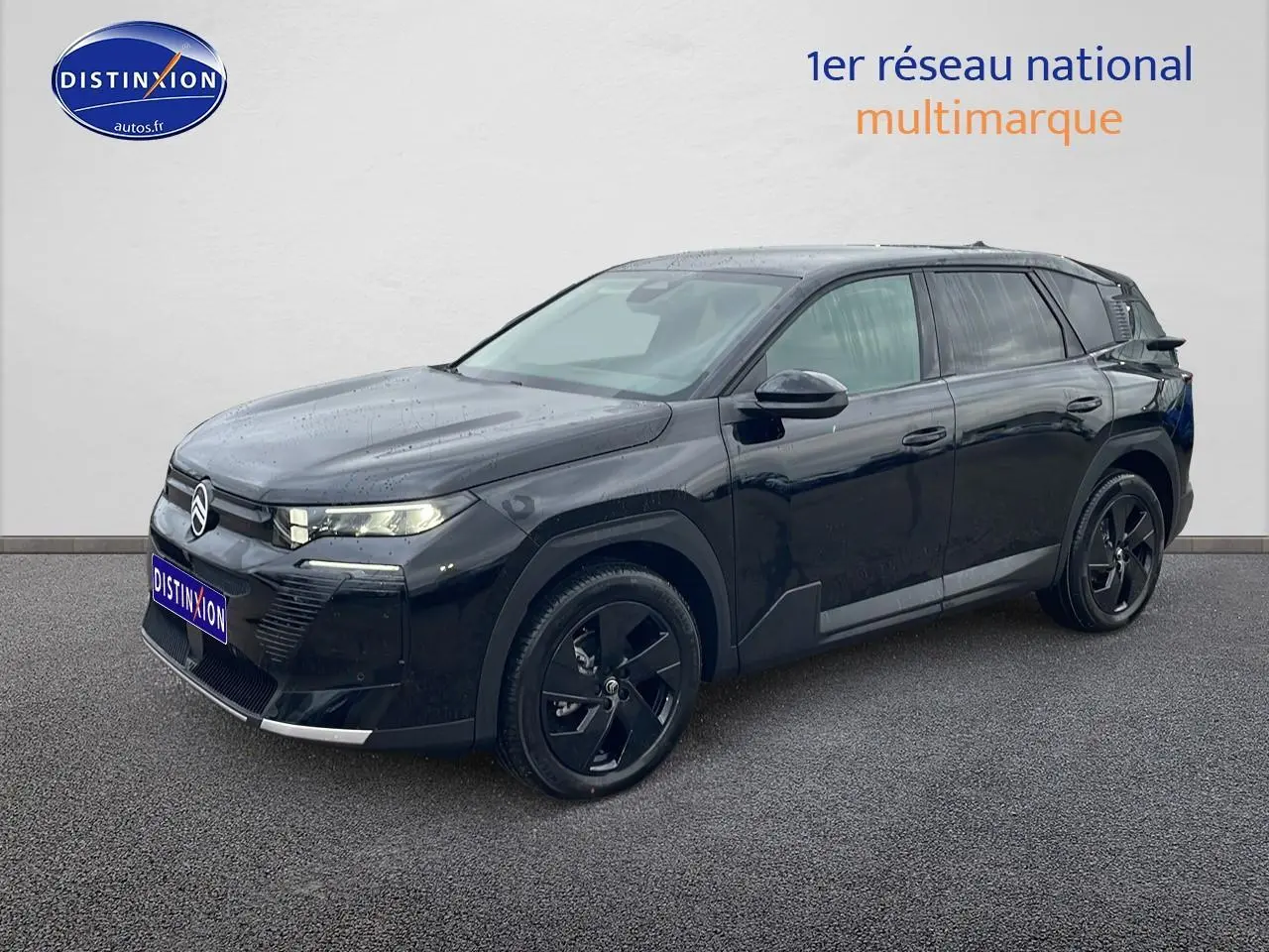 Vue 3/4 avant d'un Citroën C5 Aircross noir 2026 avec jantes alliage noires et phares LED allumés.
