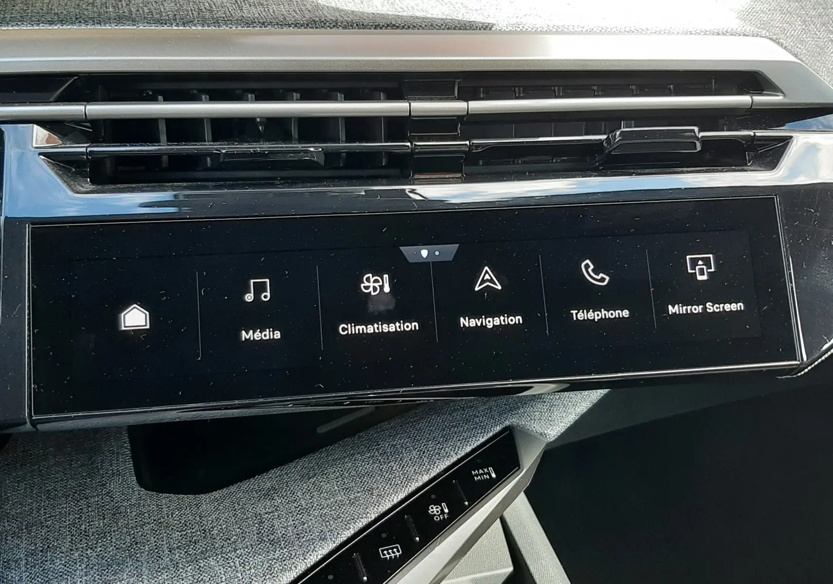 Vue rapprochée de l’écran tactile central et des commandes de climatisation du Peugeot 5008 gris titane 2025.