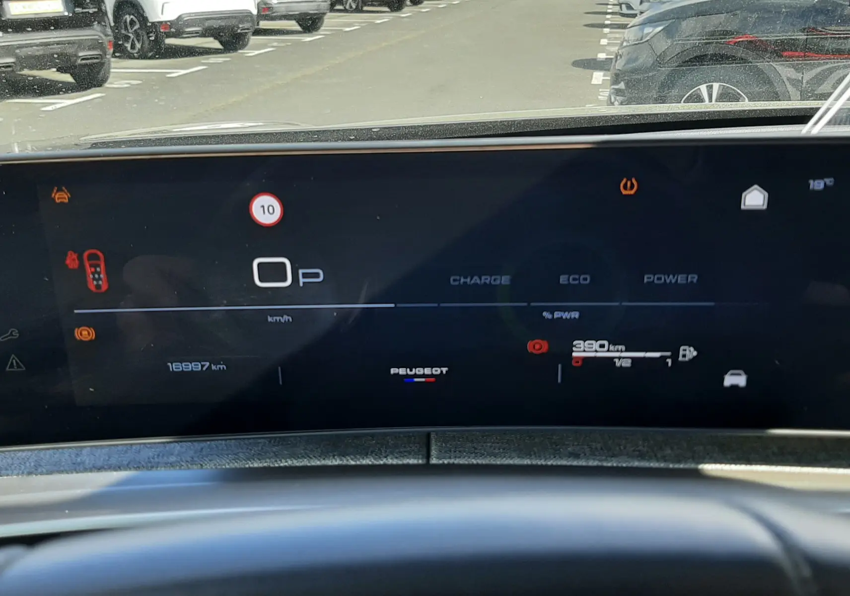 Tableau de bord numérique du Peugeot 5008 Hybrid 145ch, affichage en mode parking avec autonomie et alertes visibles.