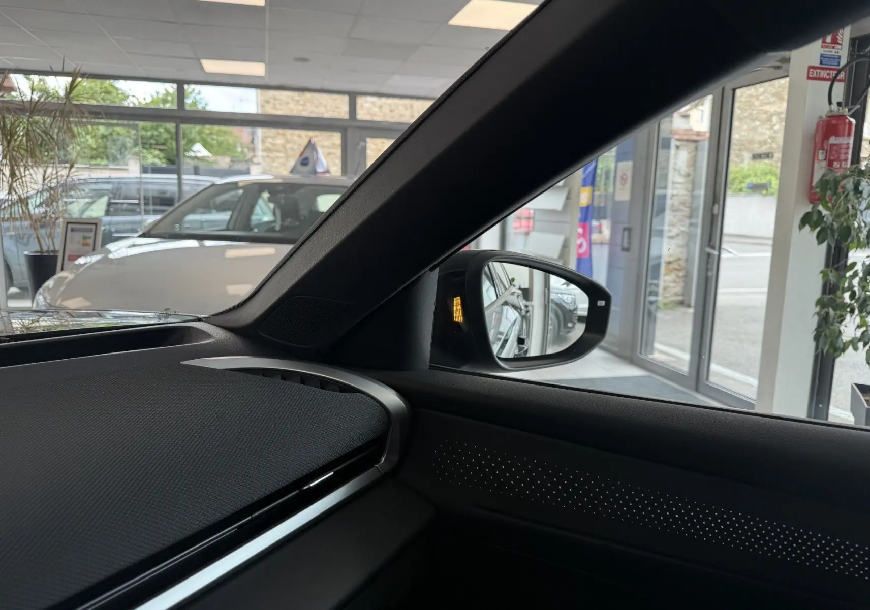 Vue intérieure côté passager du Volkswagen T-Roc R-Line noir intense 2026, avec rétroviseur et tableau de bord visibles.