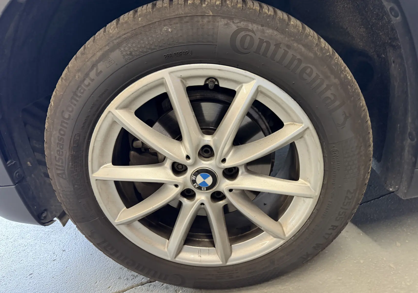 Gros plan sur la roue avant droite d’un BMW X1 noir 2019, avec jante alliage et pneu Continental visible.