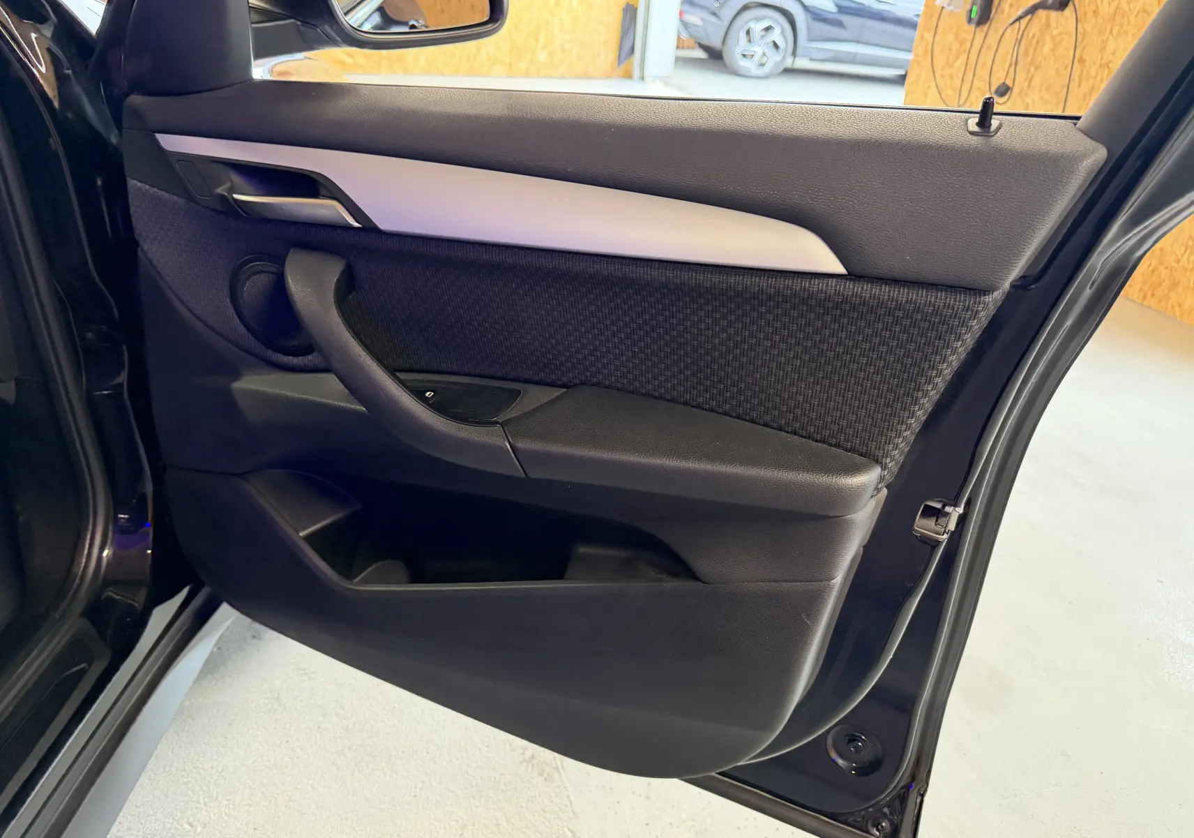 Vue intérieure de la porte arrière droite noire du BMW X1 F48 2019 avec garniture tissu et accoudoir intégré.