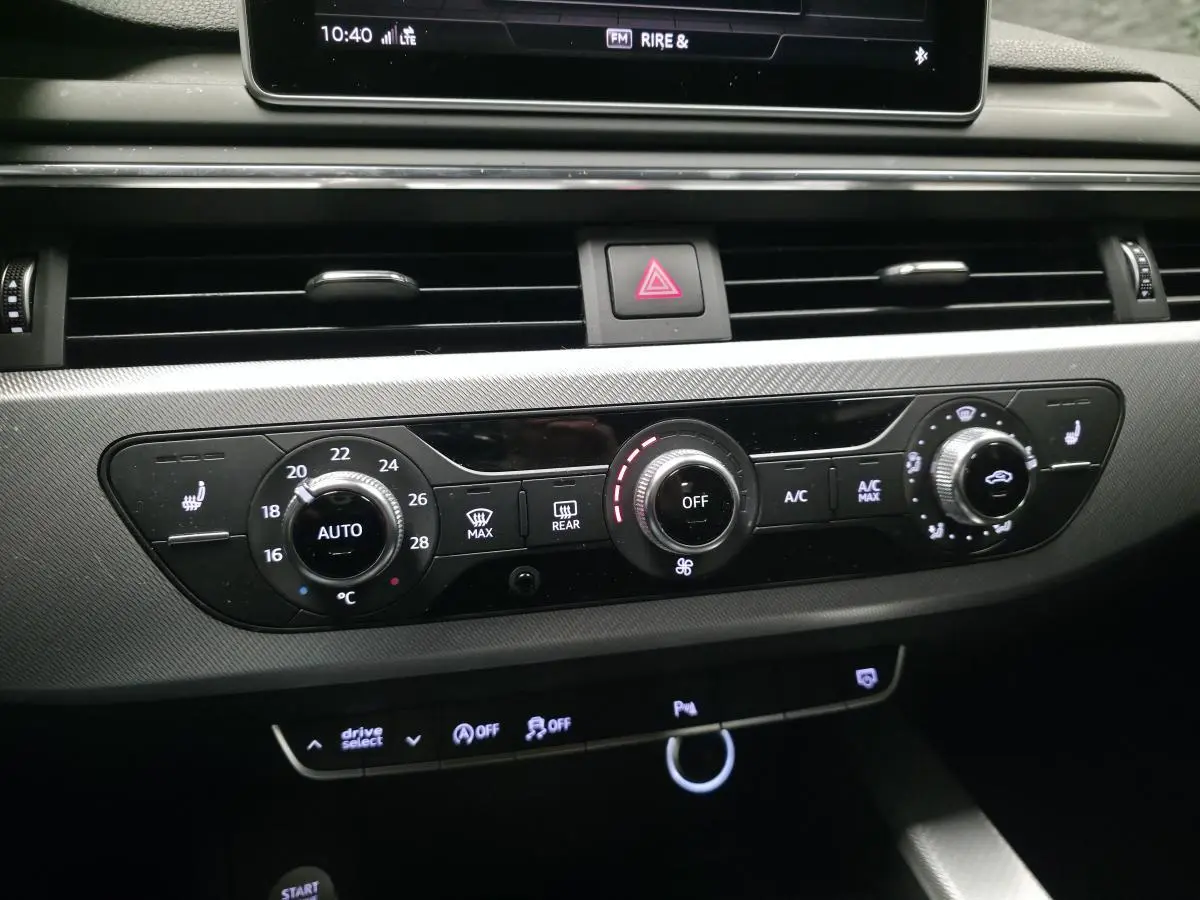 Tableau de bord de l'Audi A4 2018, vue centrée sur la console de climatisation automatique avec réglages et boutons lumineux.