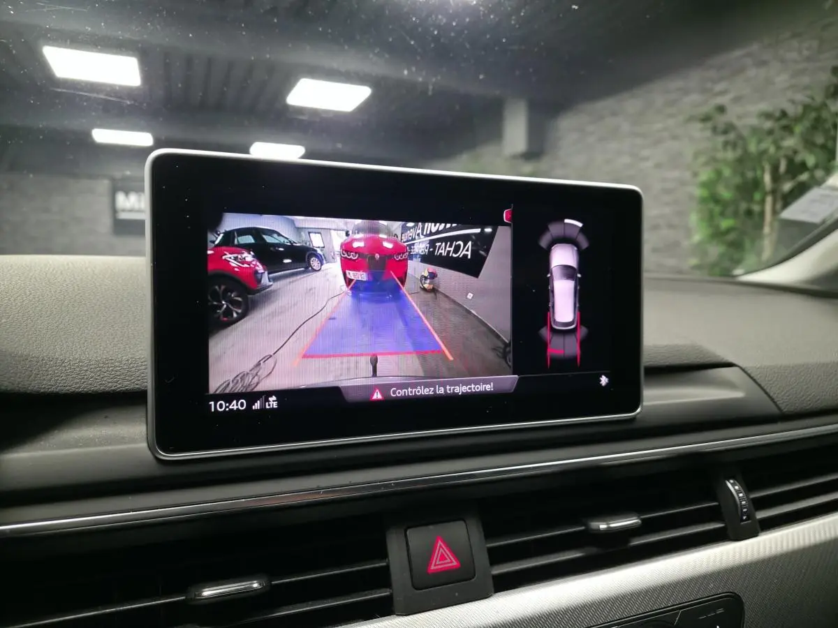 Écran de caméra de recul dans l'habitacle d'une Audi A4 Avant gris, affichant l'aide au stationnement arrière.