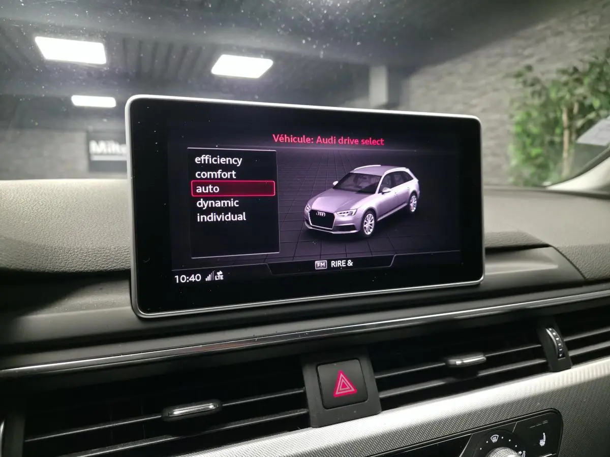 Écran central affichant le mode Audi Drive Select avec une Audi A4 gris métallisé vue de 3/4 avant droit en illustration.