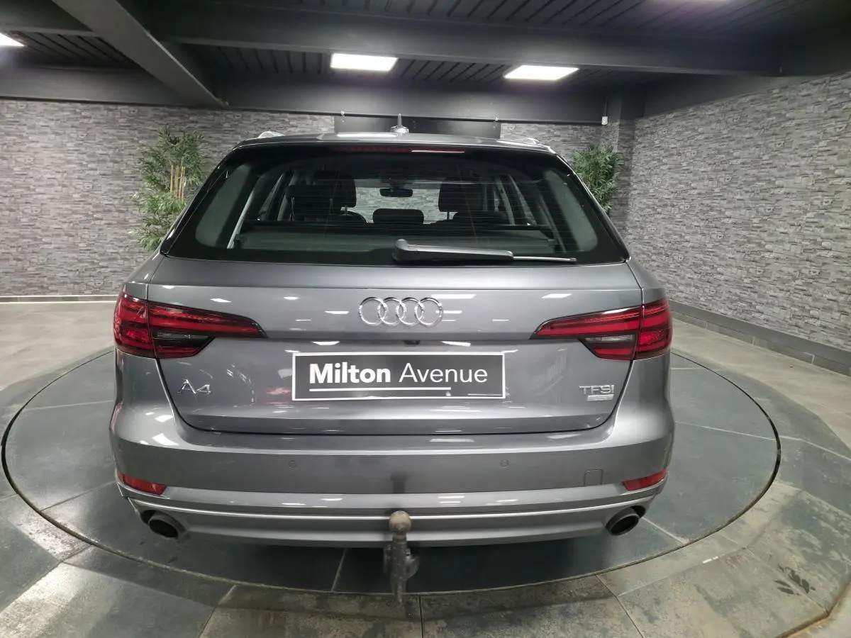 Vue arrière d'une Audi A4 Avant gris métallisé 2018 avec double sortie d'échappement et crochet d'attelage visible.