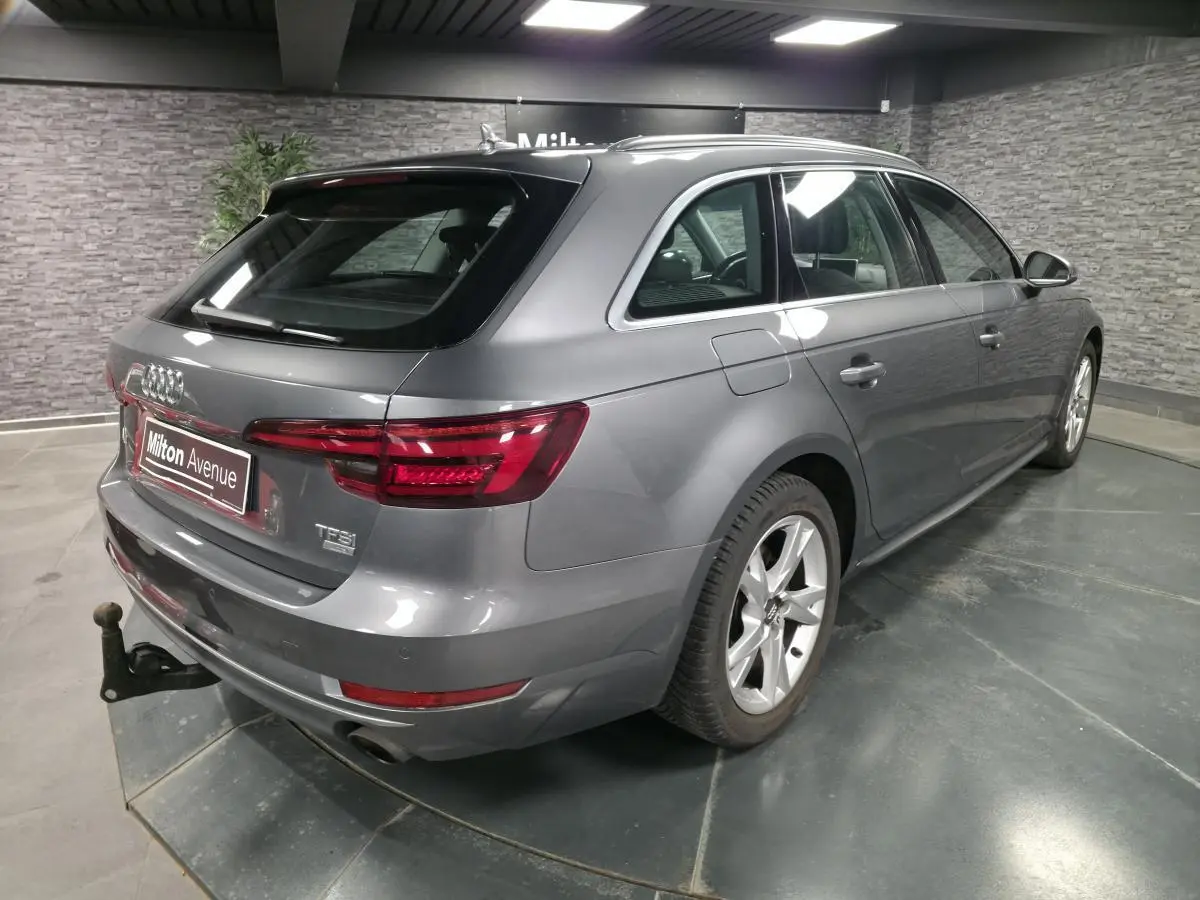 Audi A4 Avant gris métallisé vue 3/4 arrière droit avec jantes alu 17 pouces et crochet d'attelage visible.
