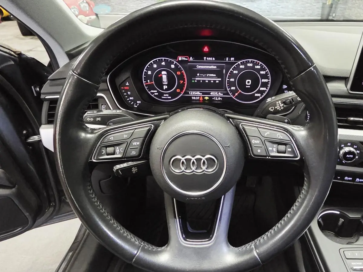 Vue rapprochée du volant cuir multifonction et du tableau de bord numérique de l'Audi A4 Avant gris 2018.