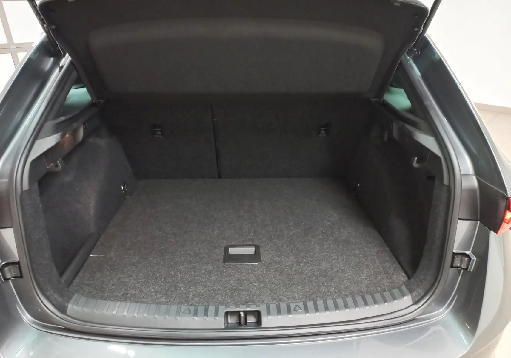 Coffre ouvert vu de l'arrière d'une Skoda Scala 2025 gris graphite, avec double plancher et finition Monte-Carlo.
