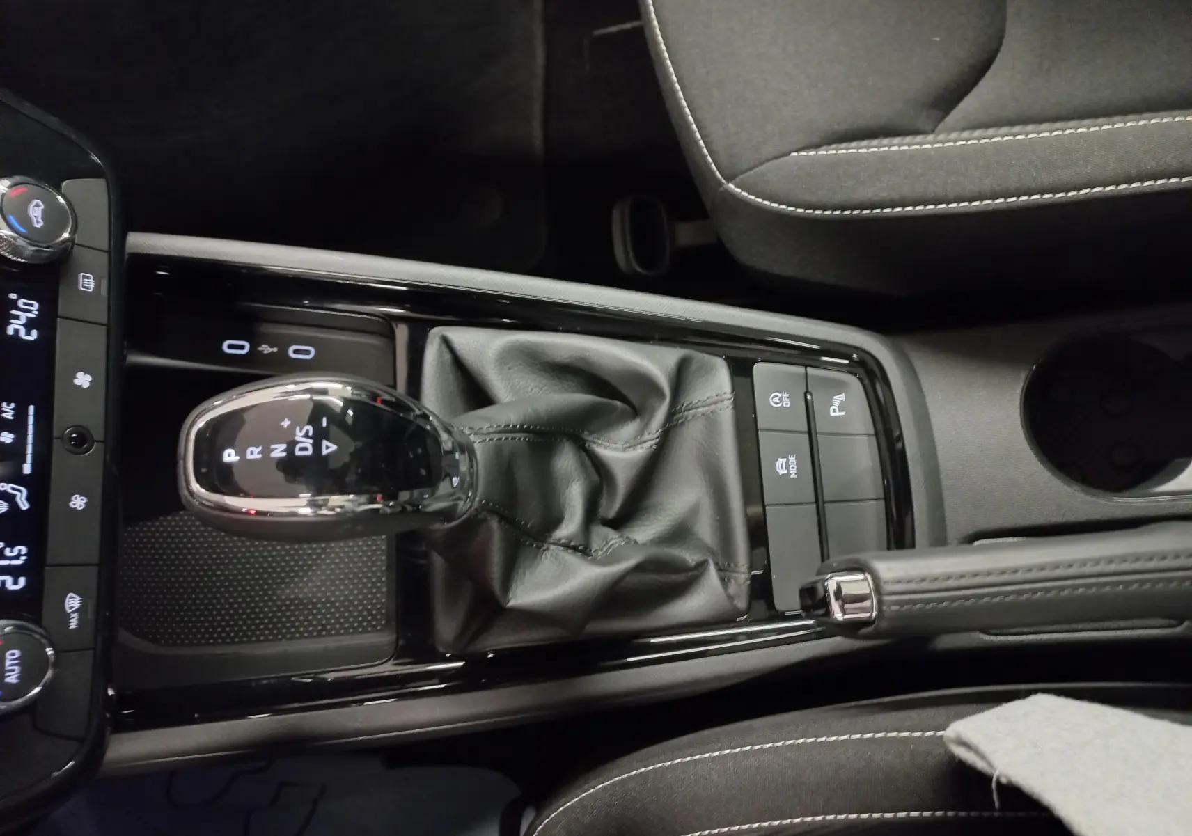 Vue rapprochée de la console centrale avec levier de vitesse automatique et frein à main du Skoda Scala gris graphite Monte-Carlo 2025.