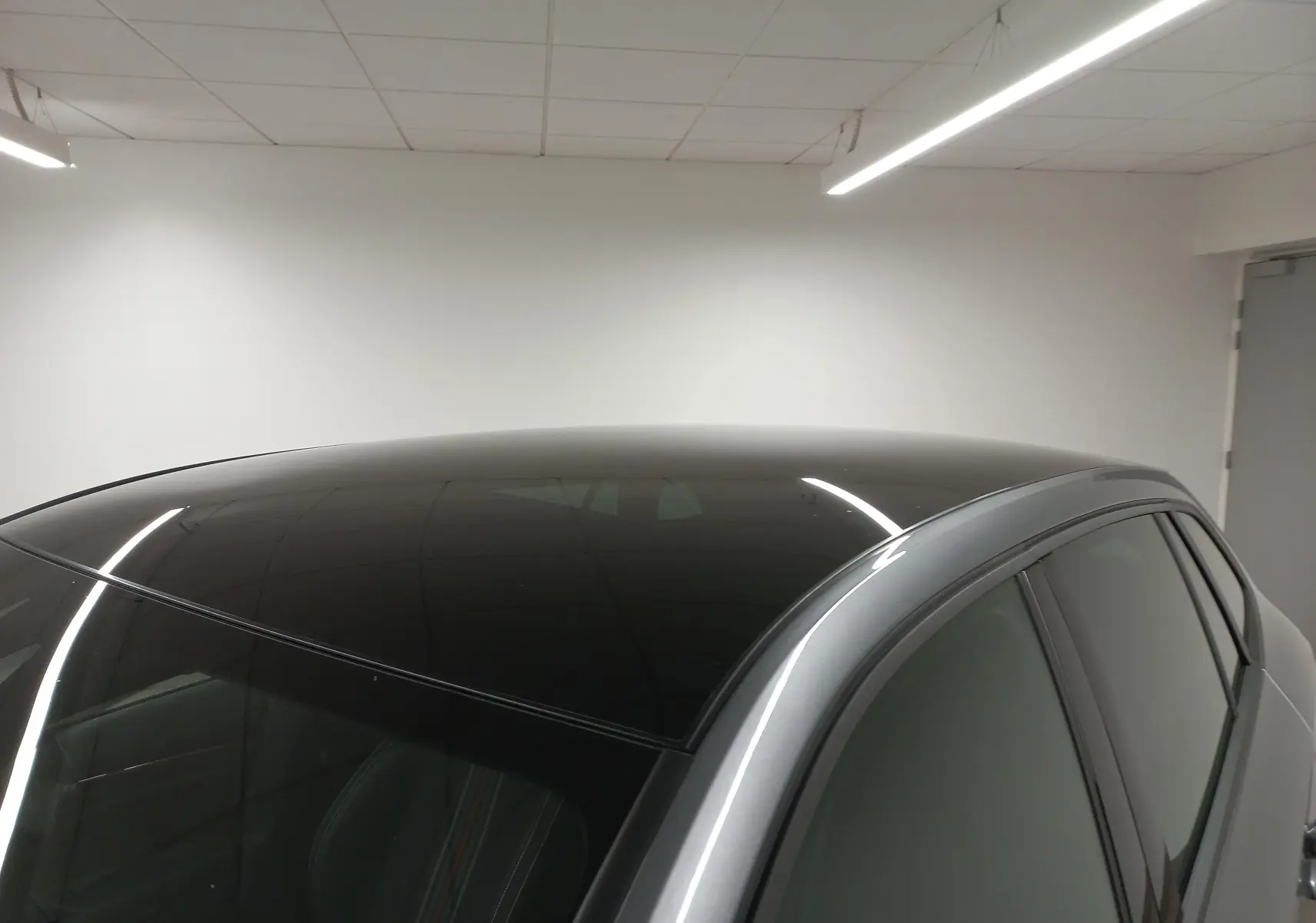 Toit panoramique noir brillant et partie supérieure gris graphite d'une Skoda Scala 2025 vue côté droit en intérieur.