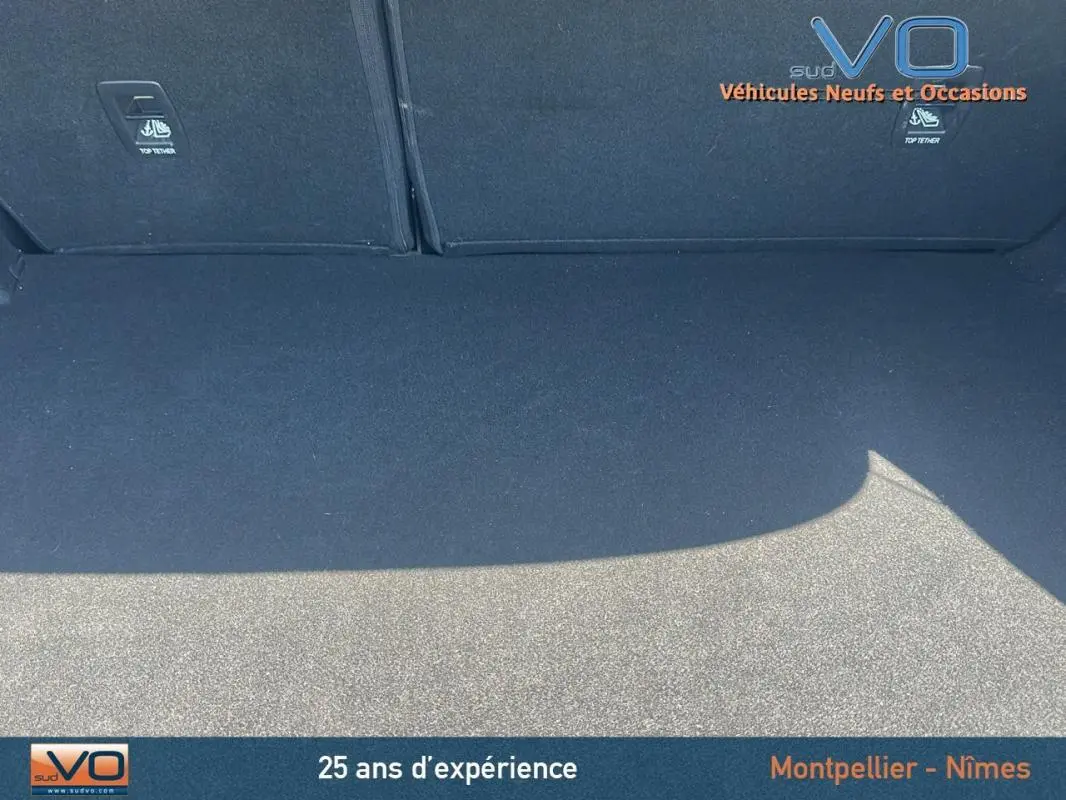 Coffre spacieux et propre de la Renault Mégane IV Berline gris, vue intérieure arrière avec sièges rabattables visibles.