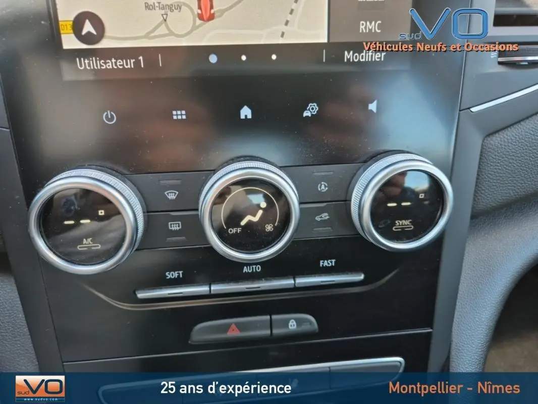 Gros plan sur la console centrale de la Renault Mégane IV Business 2020, montrant les commandes de climatisation automatique et l'écran tactile.