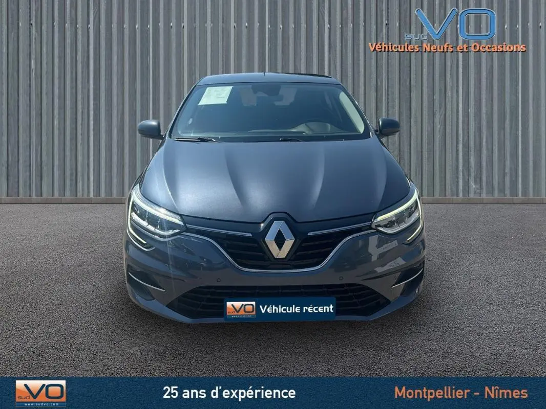 Vue frontale d'une Renault Mégane IV Berline gris métallisé avec phares LED et calandre noire brillante.