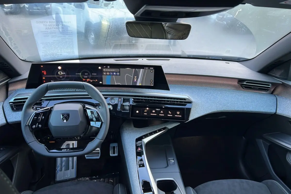 Vue intérieure frontale du Peugeot 3008 Hybrid 145 GT Alcantara avec tableau de bord numérique et volant cuir multifonctions.