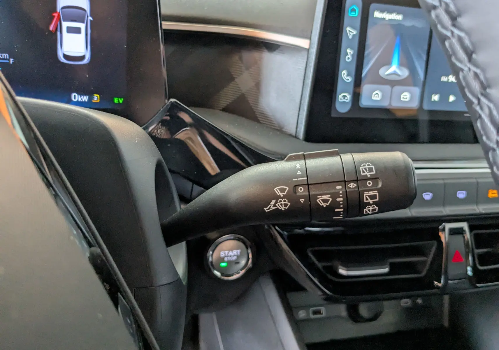 Gros plan sur la manette d’essuie-glace côté gauche du tableau de bord du MG3 1,5 Hybrid+ Luxury noir avec écran tactile et bouton start visible.