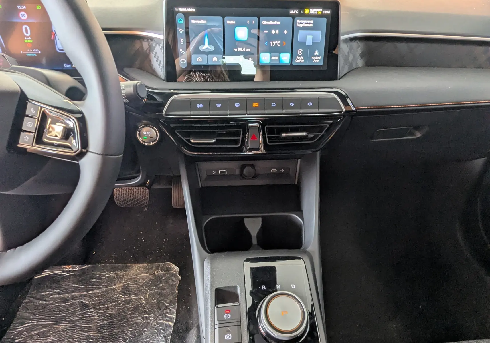 Vue intérieure centrée sur la console centrale et le tableau de bord du MG3 1,5 HYBRID+ noir avec écran tactile et commande rotative.
