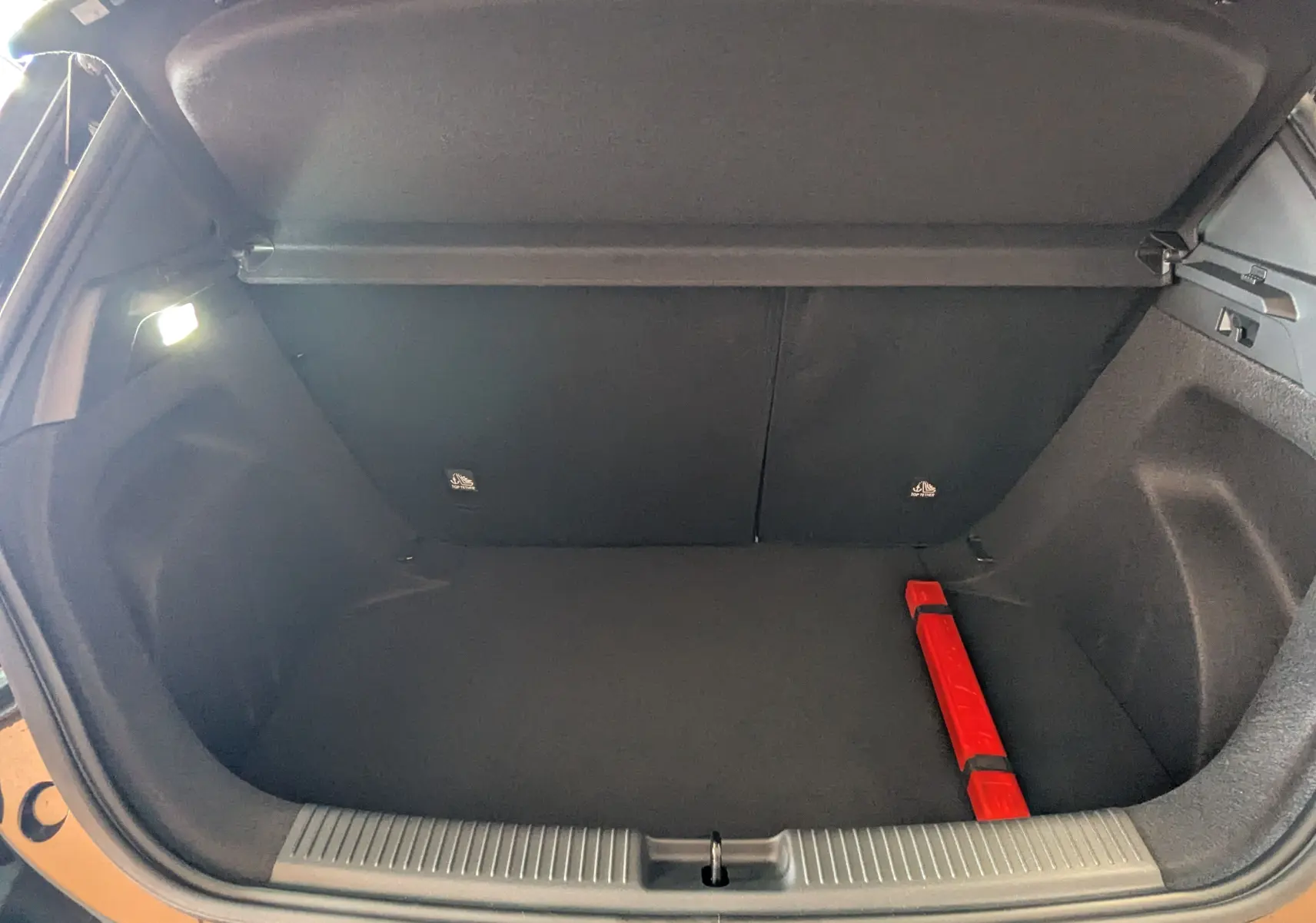 Coffre ouvert vu de face du MG3 1,5 HYBRID+ 195cv Luxury en Pebble Black, intérieur noir avec triangle de sécurité rouge.