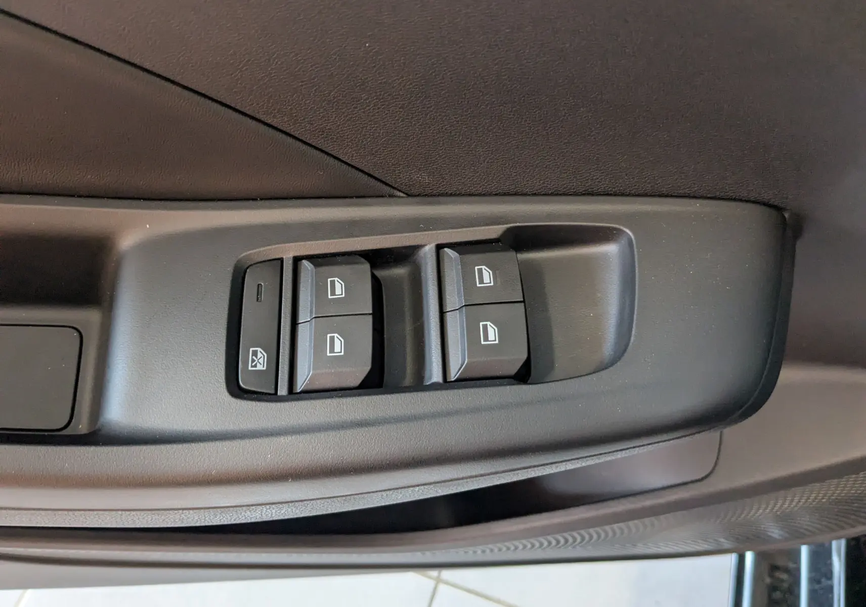 Gros plan sur les commandes des vitres électriques côté gauche de la porte d’une MG3 1,5 HYBRID+ 195cv Luxury noire.