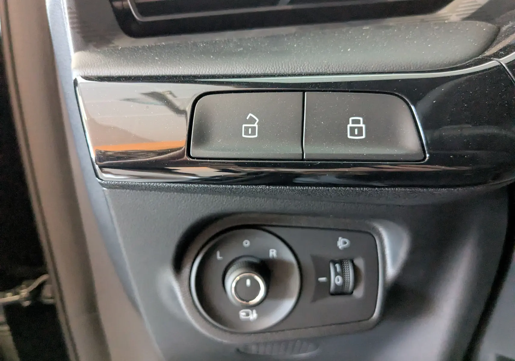 Gros plan sur les boutons de verrouillage et réglage des rétroviseurs intérieurs noirs du MG3 1,5 HYBRID+ 195cv Luxury 2026.