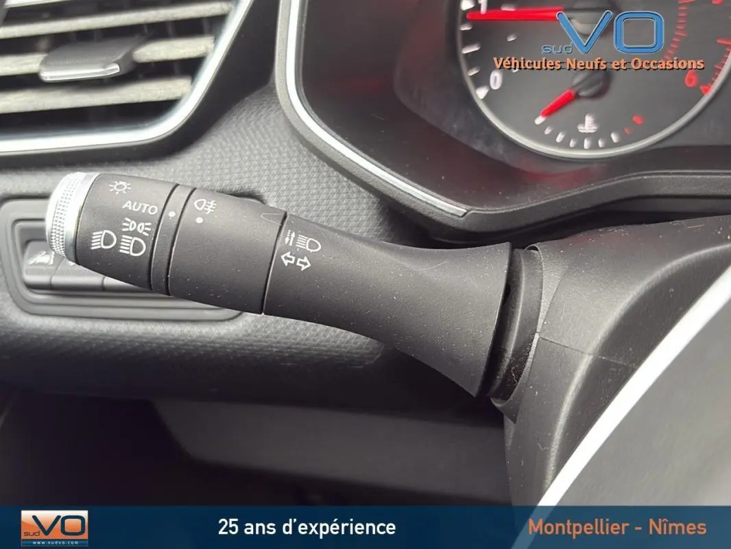 Gros plan sur la commande des feux et clignotants dans l'habitacle d'une Renault Clio gris foncé, version Business 2020.