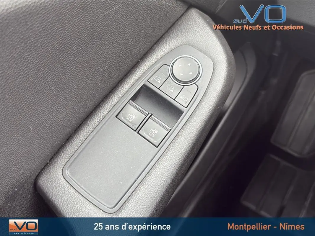 Gros plan sur les commandes des vitres électriques et rétroviseurs du côté conducteur d'une Renault Clio gris foncé V Blue dCi 85 Business 2020.