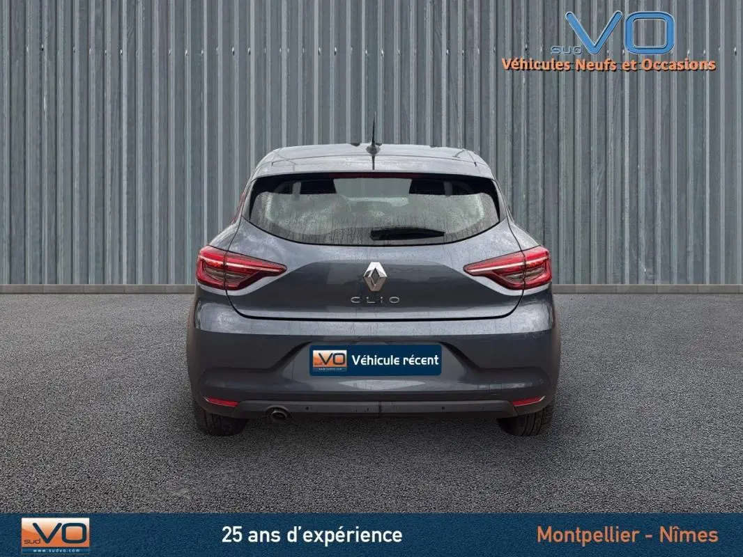 Vue arrière d'une Renault Clio V Blue dCi 85 Business gris foncé, avec feux arrière allumés et plaque "Véhicule récent".