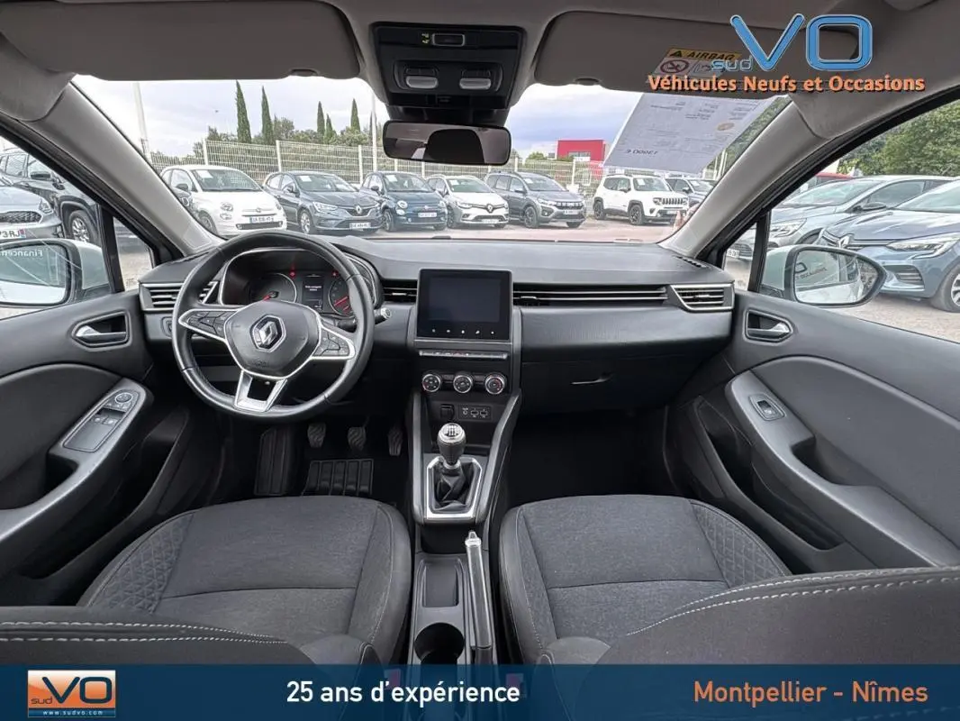 Vue intérieure avant de la Renault Clio gris foncé 2020, avec volant multifonction et boîte manuelle visible.